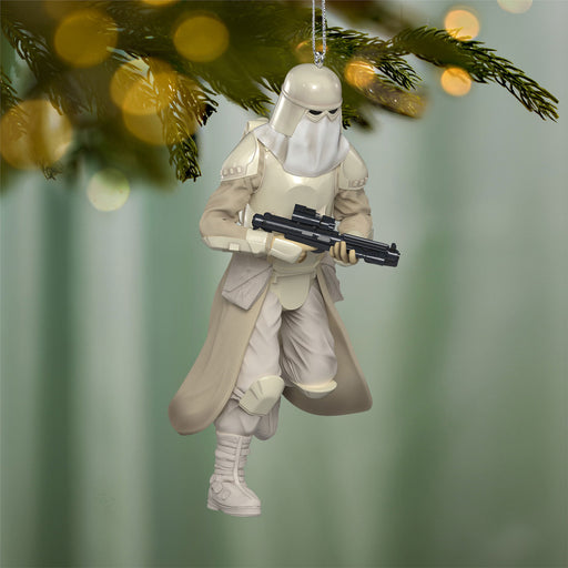 Decorative ornament of a character in a white outfit with a weapon, hanging on a Christmas tree.