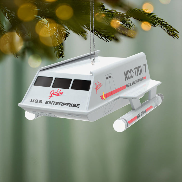 USS Enterprise model hanging on a Christmas tree with a festive background