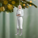 Decorative ornament of a person in equestrian attire hanging from a tree branch.