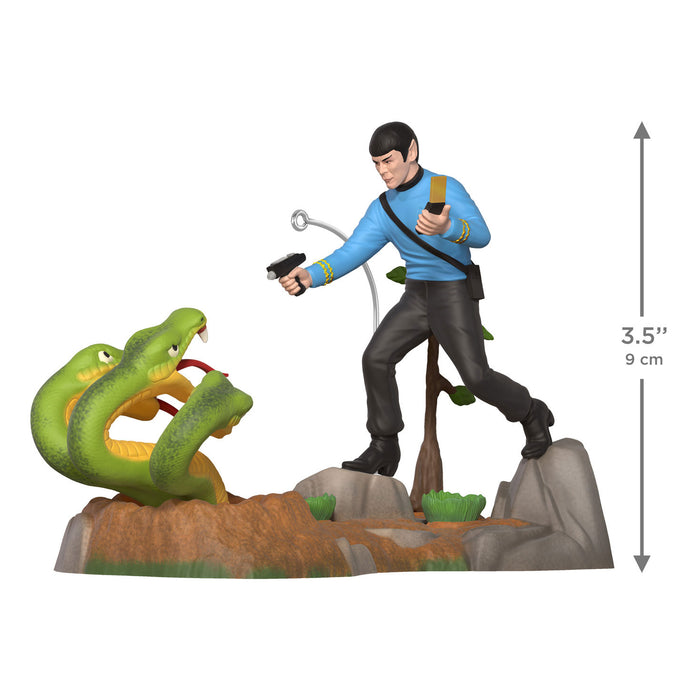 Figurine of a character in a blue shirt and black pants standing next to a green snake on a white background with a measurement indicator.