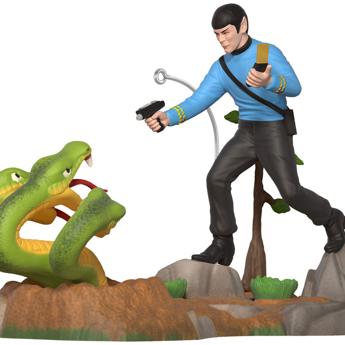 Figure of a character in a blue shirt with a weapon, standing next to a snake on a white background