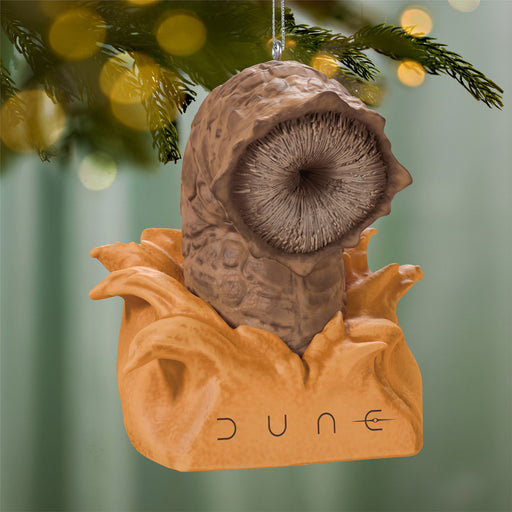 Decorative ornament shaped like a character from 'Dune' hanging on a Christmas tree.