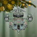 Decorative robot ornament hanging on a Christmas tree with a festive background.