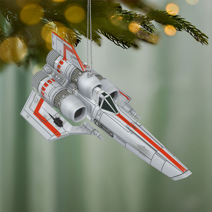 Star Wars spaceship ornament hanging on a Christmas tree with a blurred green background