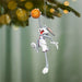 Decorative ornament of a cartoon character holding a basketball, hanging from a Christmas tree.