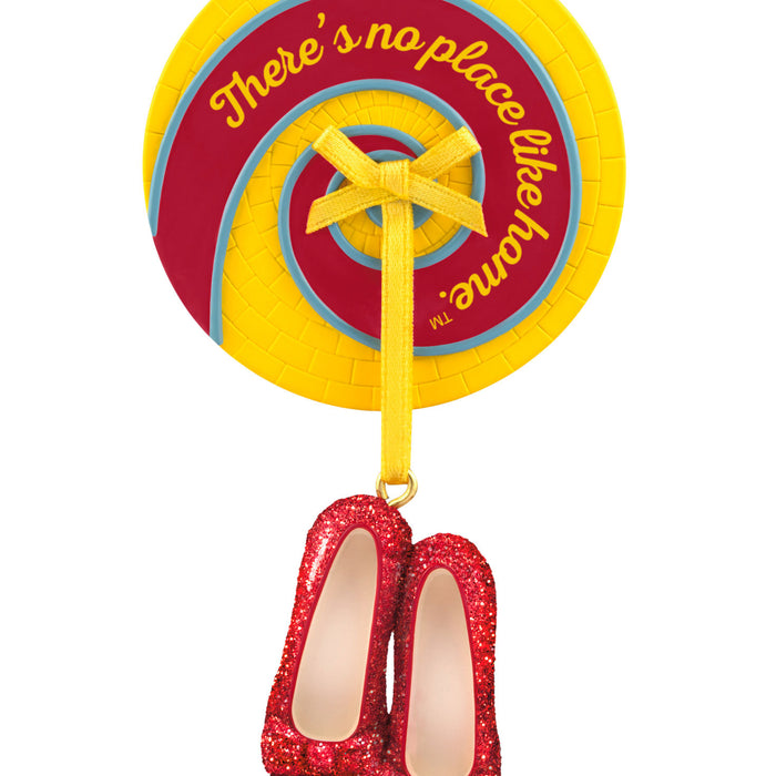 Decorative item with red shoes, yellow ribbon, and circular sign on a white background