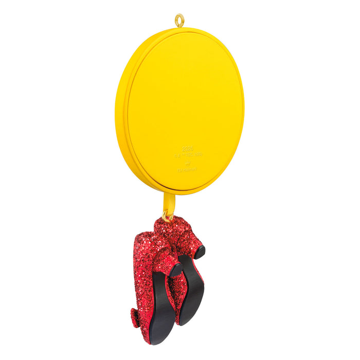 Yellow mirror with red glittery bow and black shoes on a white background