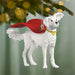 Dog ornament with a red cape and yellow bow tie hanging from a Christmas tree.