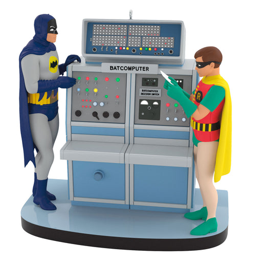 Figurines of Batman and Robin interacting with a Batcomputer on a white background