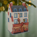 Decorative house ornament with lit windows on a green background