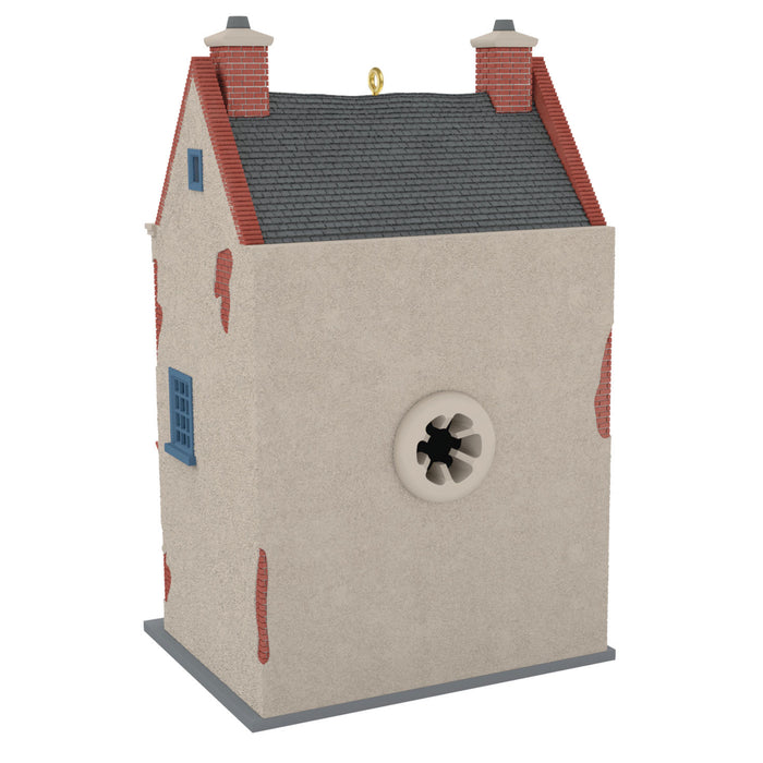 Decorative birdhouse with a gray roof, red chimneys, and blue windows on a white background