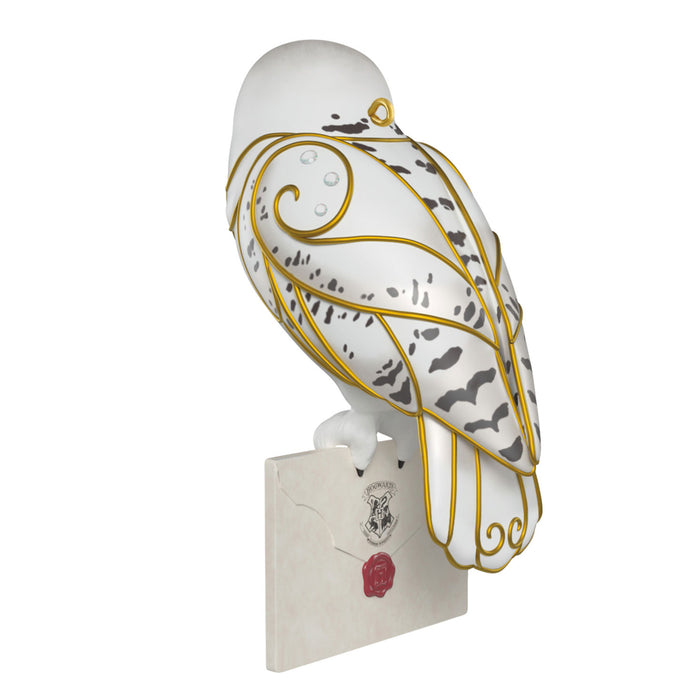 Decorative owl figurine with gold and black patterns on a white background
