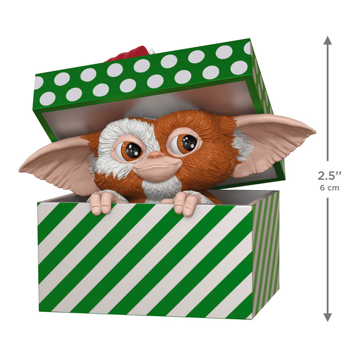Gizmo toy figure peeking out from a green and white striped box with a polka dot lid.