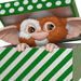 Animated character with large eyes and wings peeking out from a green and white striped box.