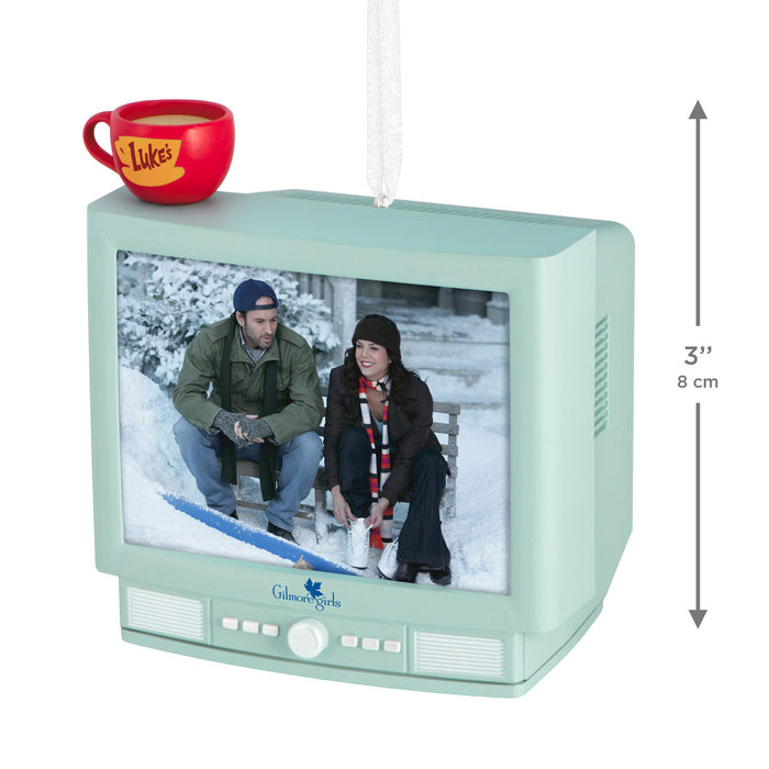 Decorative ornament shaped like a vintage television with a couple on screen and a red mug labeled 'Luke's'.