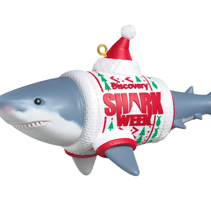 Shark-shaped ornament with 'Discovery Shark Week' sweater and Santa hat on a white background