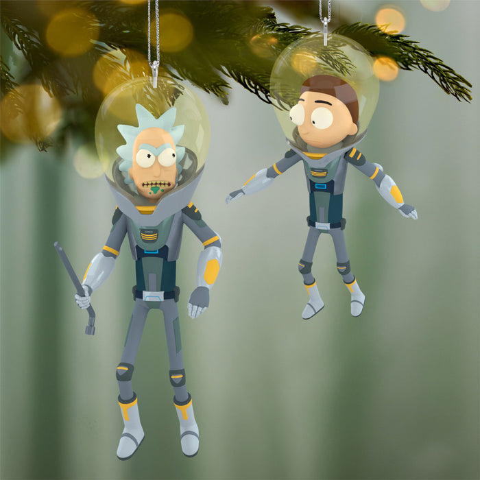 Two cartoon character ornaments in space suits hanging from a Christmas tree.