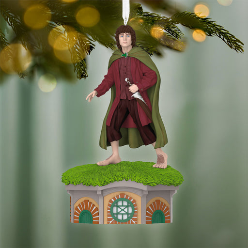Ornament of a character in a green cloak and red outfit on a small platform with a blurred green background