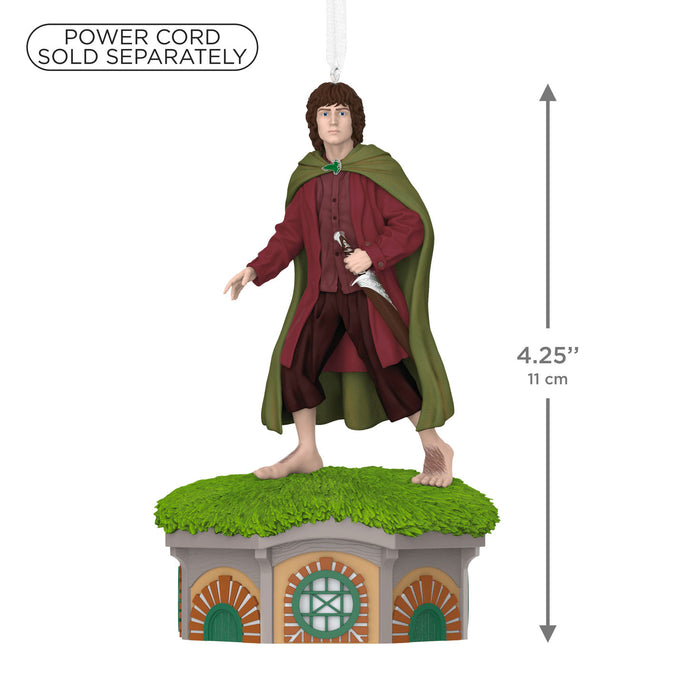 Decorative figure of a character in a green cloak and red robe standing on a small house with grass roof, dimensions indicated.
