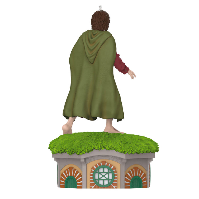 Statue of a character in a green cloak standing on a small building with grass roof