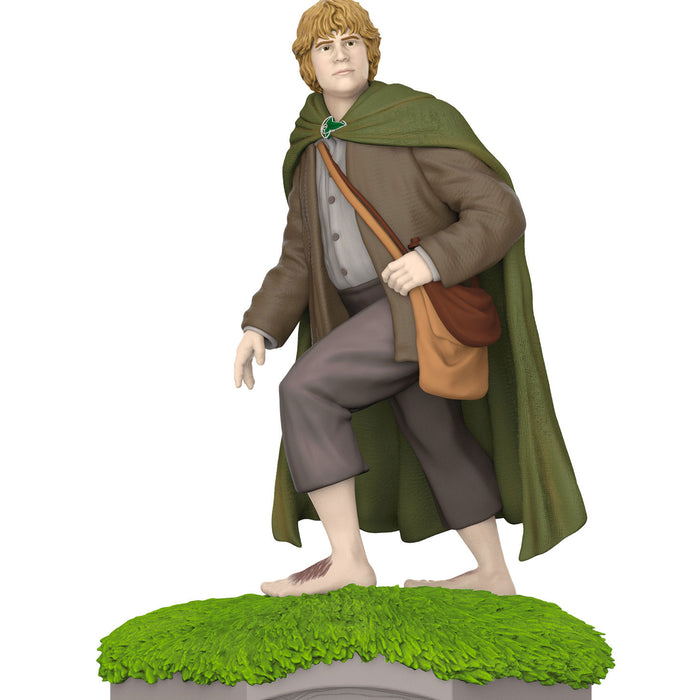 Figure of a character in fantasy attire with a green cloak and brown bag on a white background