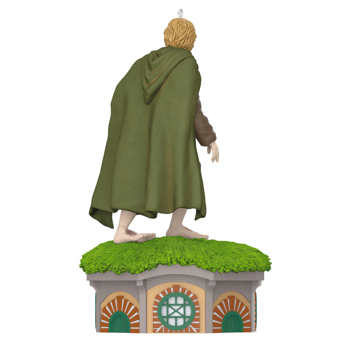 Figure of a character in a green cloak standing on a small building with grass roof