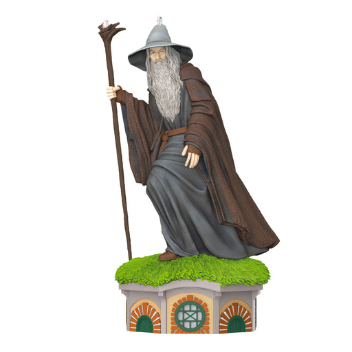 Statue of a wizard with a staff on a small platform with grass, on a white background