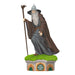 Statue of a wizard with a staff on a small platform with grass, on a white background
