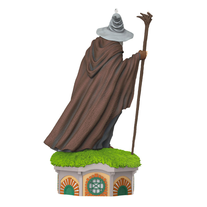Statue of a wizard in a brown robe with a staff on a green platform