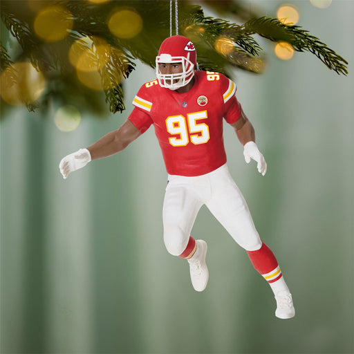 Decorative football player ornament in red and white uniform with number 95, hanging from a tree.