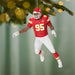 Decorative football player ornament in red and white uniform with number 95, hanging from a tree.