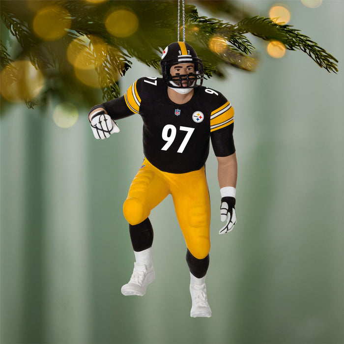 Decorative football player ornament with black and yellow uniform hanging on a Christmas tree.