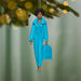 Decorative ornament of a woman in a blue outfit holding a suitcase, hanging from a tree.