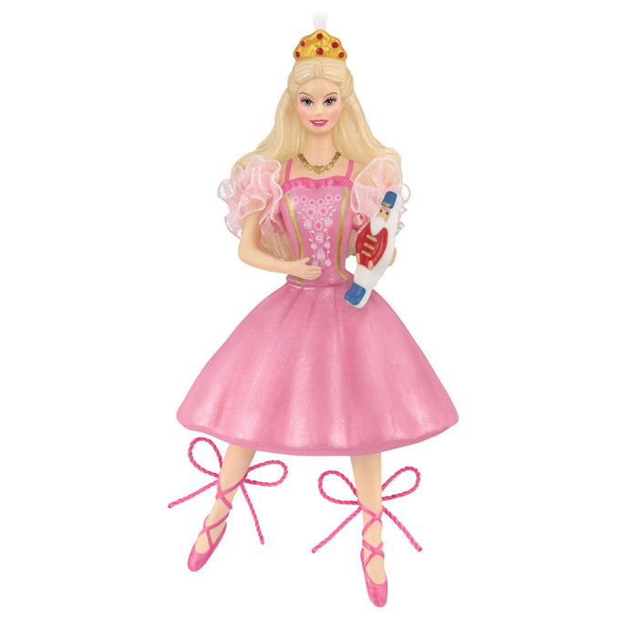 Barbie doll in a pink dress with a crown and ballet shoes on a white background