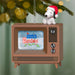 Vintage television ornament with Snoopy wearing a Santa hat, displaying 'A Charlie Brown Christmas' on screen, against a festive green background.
