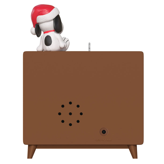 Small dog figurine wearing a red hat on top of a brown rectangular object with a central circular hole.