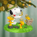 Christmas ornament featuring Snoopy and Woodstock in a camping scene with a green background.