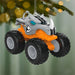 Monster truck Christmas ornament hanging on a tree with a blurred green background