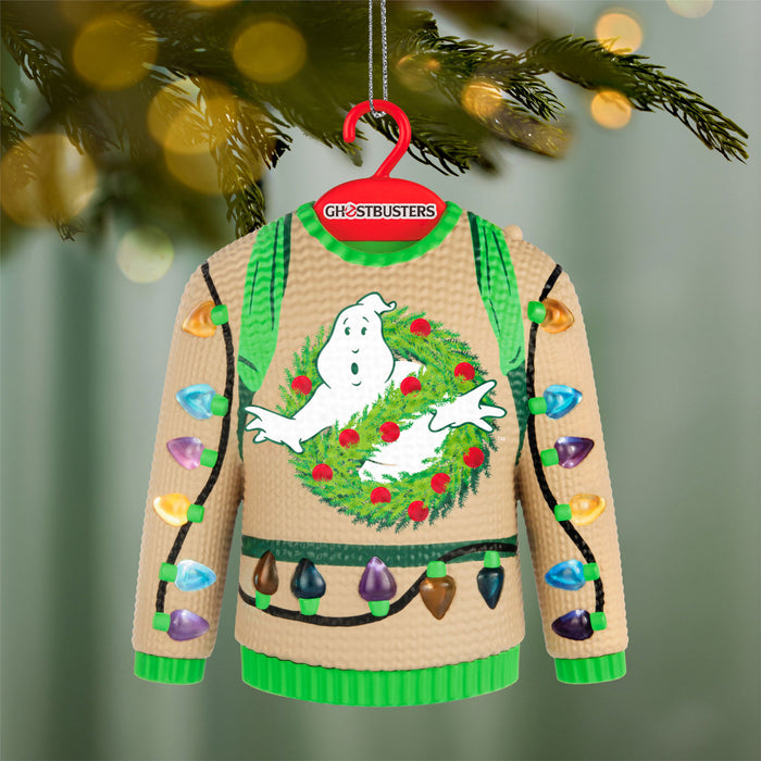 Ghostbusters sweater ornament with a ghost and wreath design, hanging on a Christmas tree.