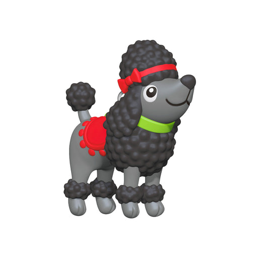 Toy poodle figure with a red bow and green collar on a white background