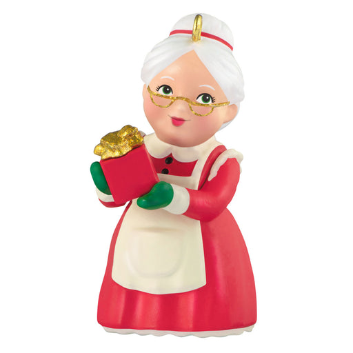 Christmas ornament of a woman in a red dress holding a gift box on a white background