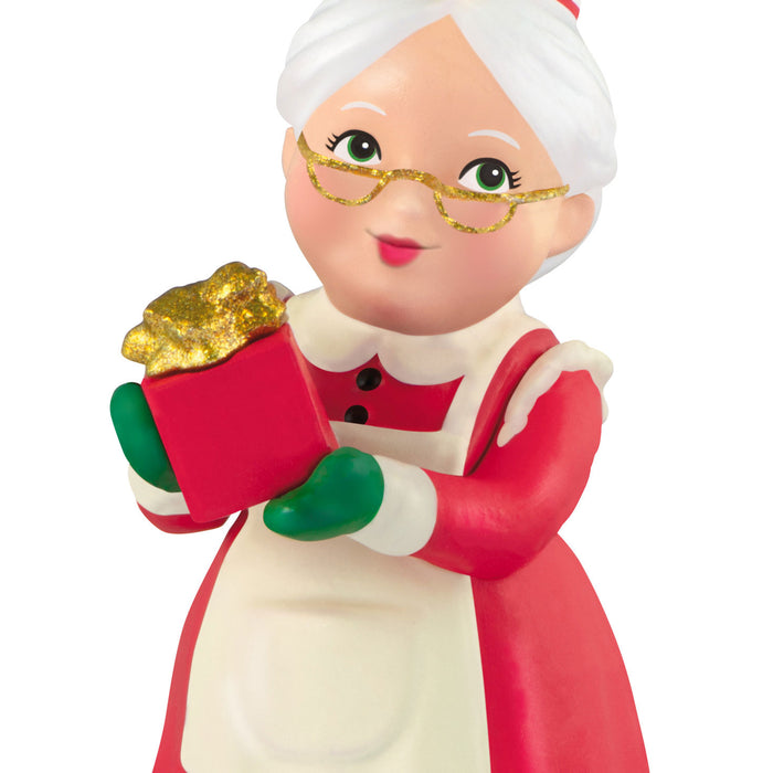 Figurine of a character in a red outfit with a gold gift, on a white background