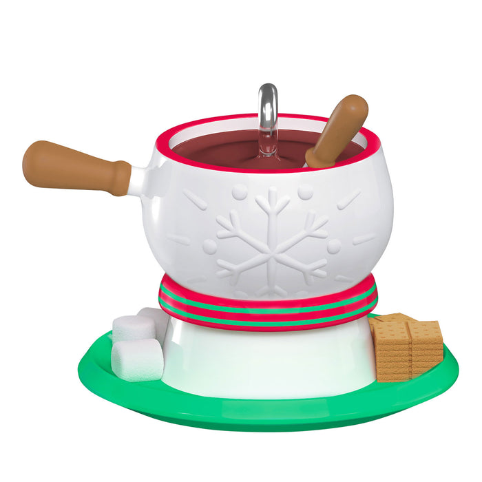 White fondue pot with snowflake design, brown handles, and green base on a white background