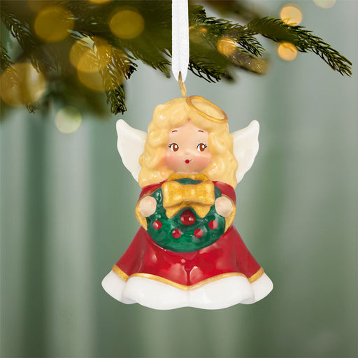 Angel Christmas ornament with wreath hanging on a tree