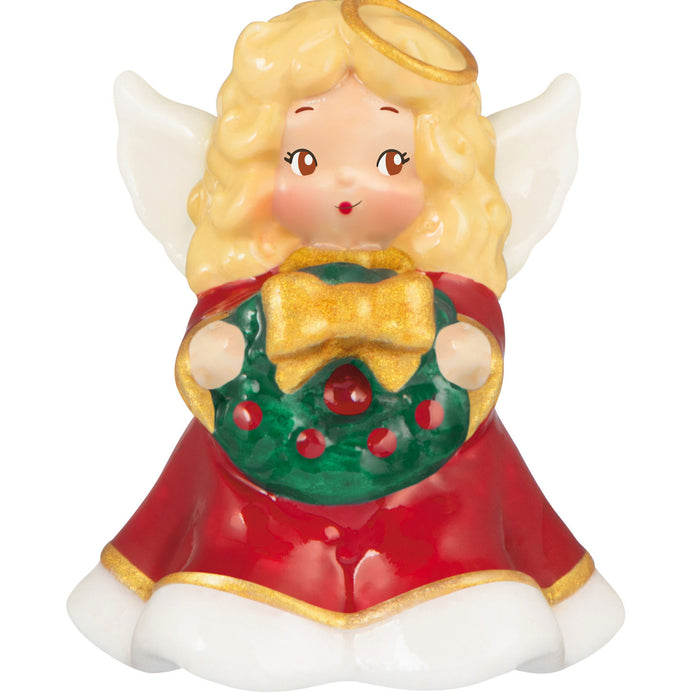 Christmas angel figurine holding a wreath on a white background