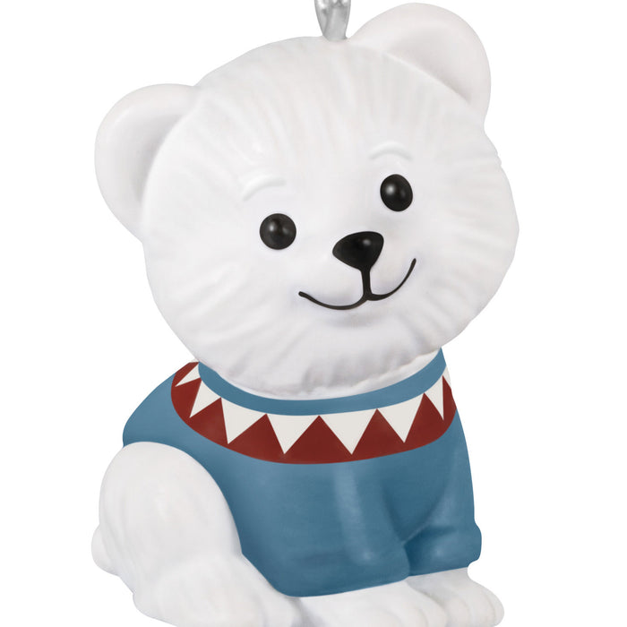 White bear ornament with a blue sweater and red collar on a white background