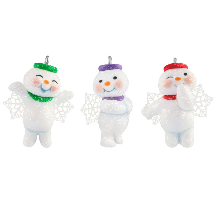 Three snowman ornaments with colorful hats on a white background