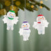 Three snowman ornaments with colorful hats hanging on a Christmas tree.