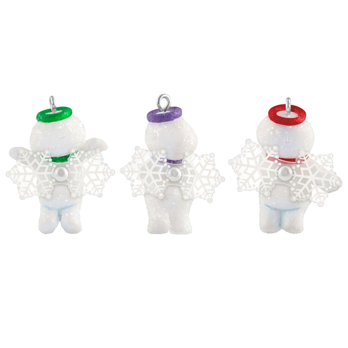 Three small angel figurines with colorful hats on a white background