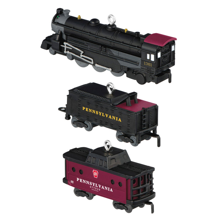 Model train set with black locomotive and red passenger cars on a white background